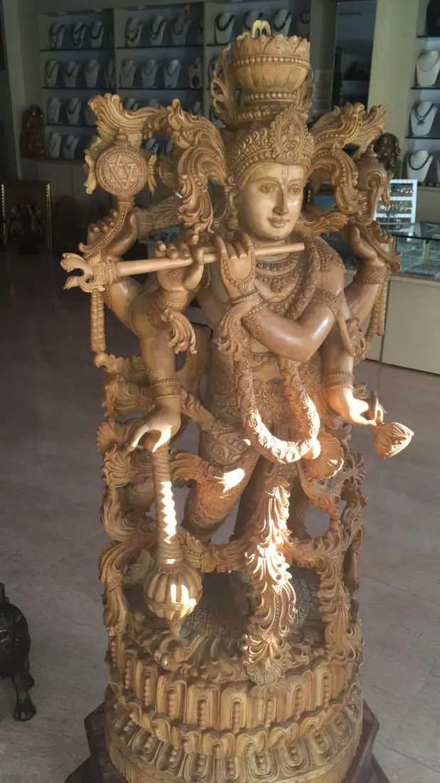 Coluna de pedra esculpida com figuras entrelaçadas